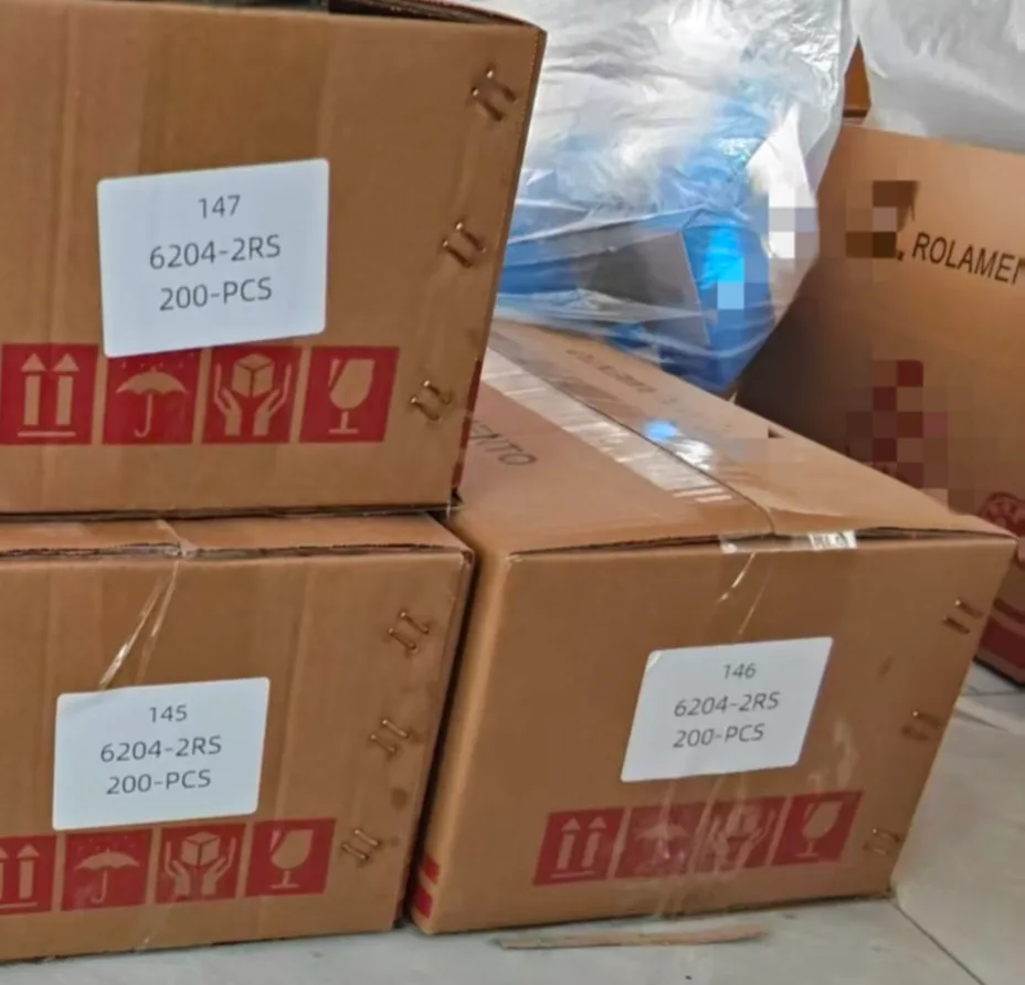 Stacked export cartons of 6204-2RS deep groove ball bearings, labeled with quantity (200-PCS) and standard handling pictograms (fragile, keep dry).